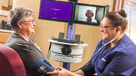 woman with nurse on video chat with doctor